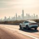 Electric vehicle driving on scenic U.S. highway in 2025.