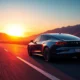 Electric vehicle on a scenic U.S. highway at sunset.