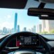 Modern vehicle interior with telematics device monitoring usage-based auto insurance in a city setting